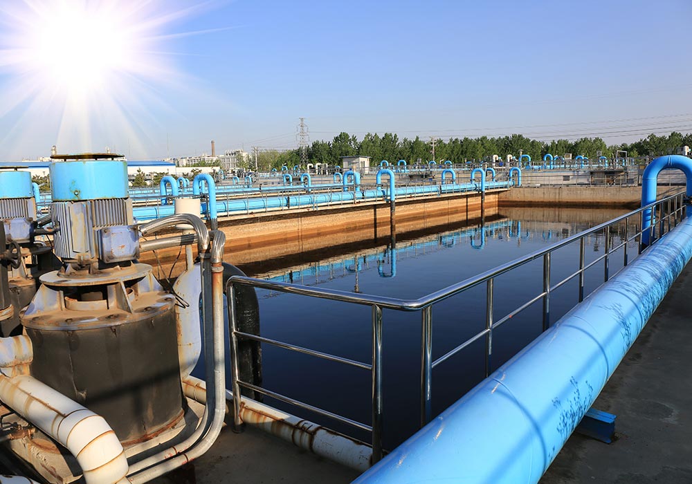 Water is passing through a basin at a wastewater treatment plant where microscopic organisms in the water further break down materials in the water. 